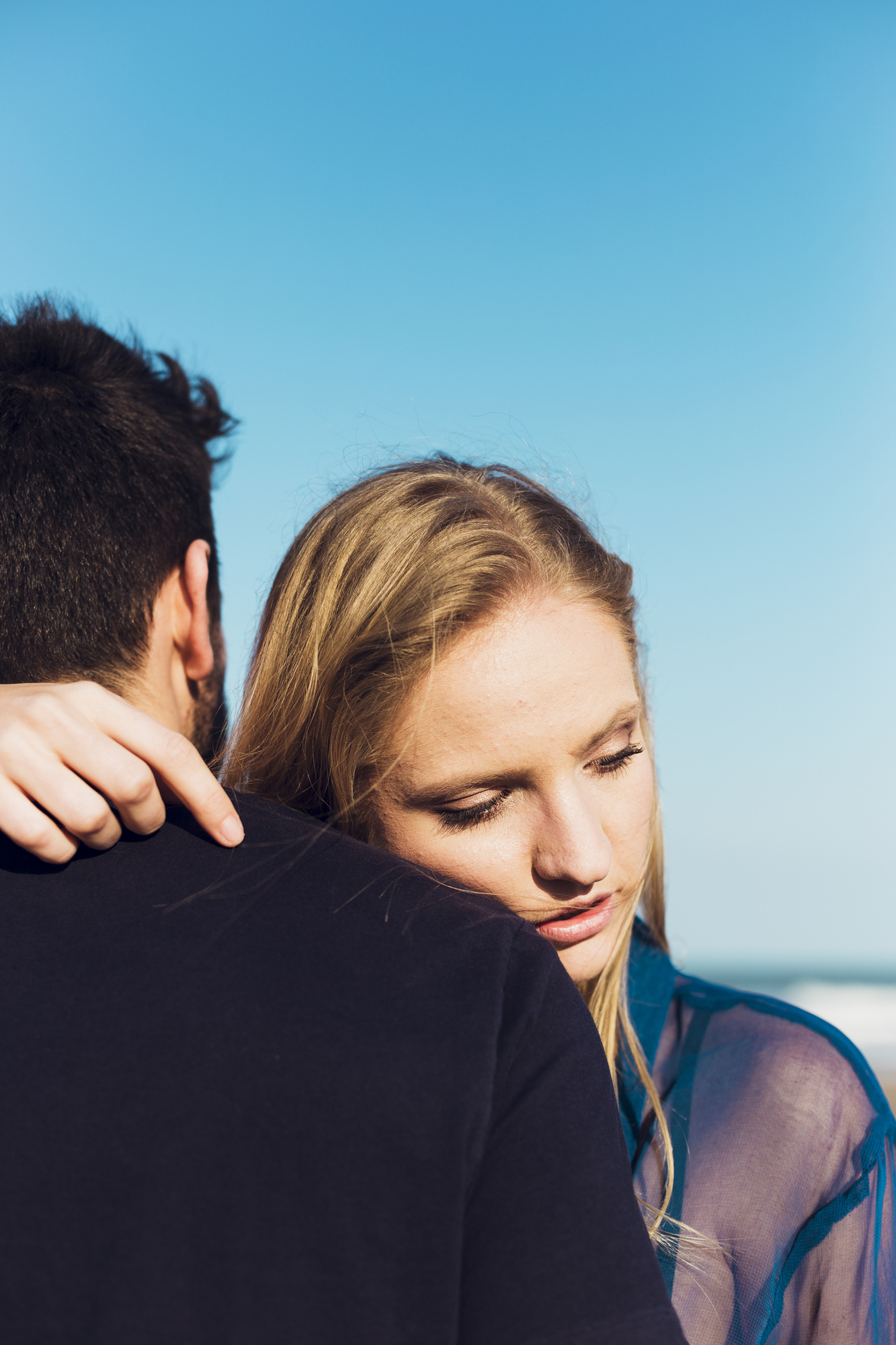 Woman-embracing-man-beach